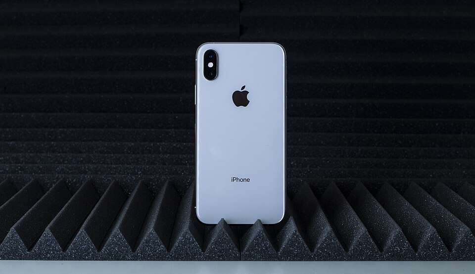 iPhone dengan Siri, asisten suara Apple yang kini ditingkatkan dengan AI